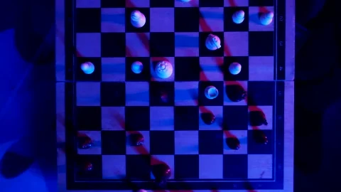 A young man plays chess with a blue background Stock Footage 139499490