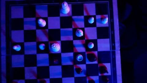 A young man plays chess with a blue background Stock Footage 139499496