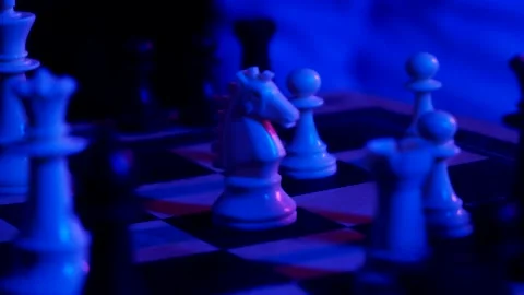 A young man plays chess with a blue background Vídeo Stock 139499509