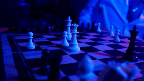 A young man plays chess with a blue background Stock Footage 139499531