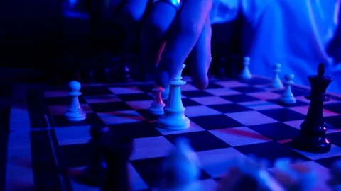 A young man plays chess with a blue background Stock Footage 139499538