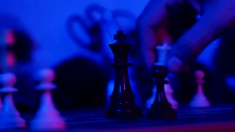 A young man plays chess with a blue background Stock Footage 139499549