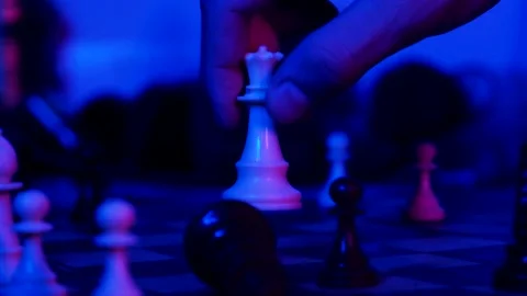 A young man plays chess with a blue background Stock Footage 139499557