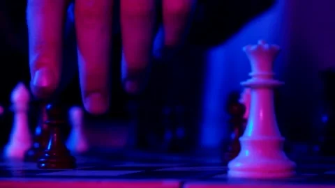 A young man plays chess with a blue background Stock Footage 139499562