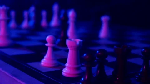 A young man plays chess with a blue background Stock Footage 139499578