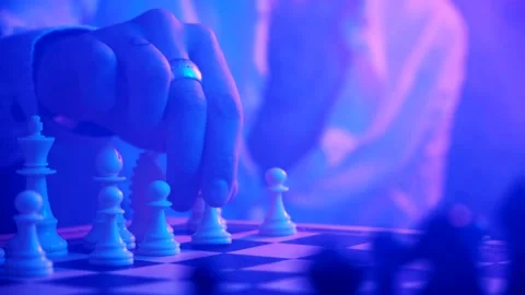 A young man plays chess with a blue background Stock Footage 139499799