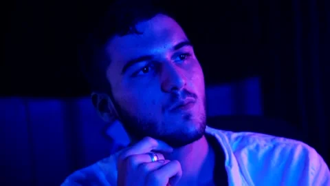 A young man plays chess with a blue background Stock Footage 139499804