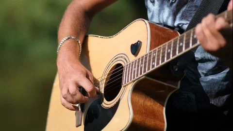 The young man plays the  guitar  on the background of nature . close up. Stock Footage 114432963