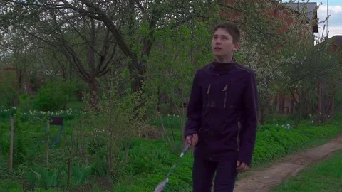 A young man plays with a racket and a shuttlecock in badminton. Slow-mo Stock Footage 75920872