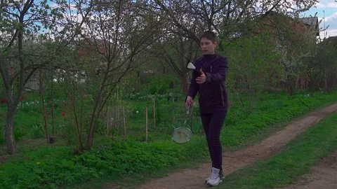 A young man plays with a racket and a shuttlecock in badminton. Slow-mo Video stock 75921281