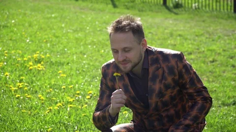 A young man plucked flower from clearing near the business center. Stock Footage 130140929