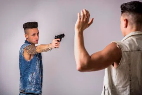 Young Man Pointing a Gun to Another Guy Stock Photos