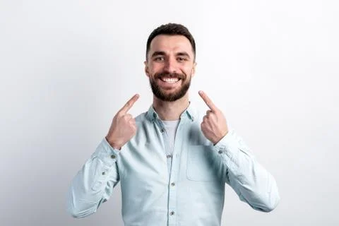 Young man pointing to his teeth. Dental care, taking care of teeth. Stock Photos