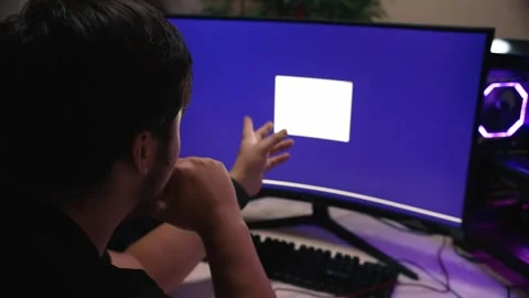 Young man pointing at installation window on computer with widescreen monitor Stock Footage 323438211