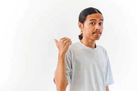 Young man pointing to the side with a confused expression Stock Photos