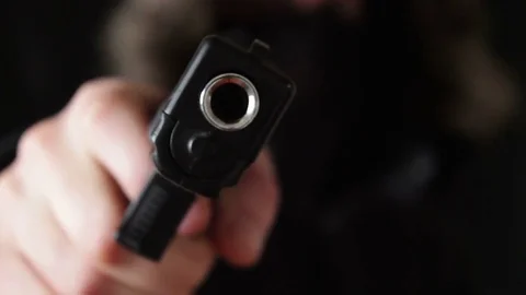 The young man points the gun at the camera Stock Footage 73710336