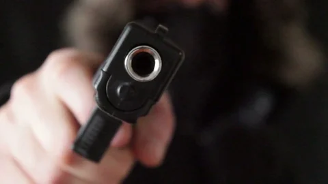 The young man points the gun at the camera Stock Footage 73711091