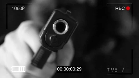 The young man points the gun at the hidden camera,black background Video stock 73715655