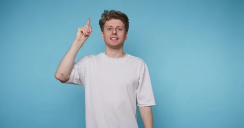 Young man points upward with a finger, portraying inspiration and bright id.. Stock Footage 313281074