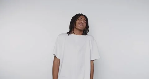 Young man poses in different expressions in a studio setting with plain bac.. Vídeos de archivo 328248621