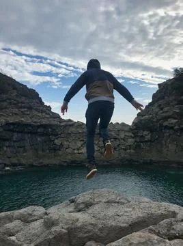 Young man posing and jumping on the sea side Stock Photos