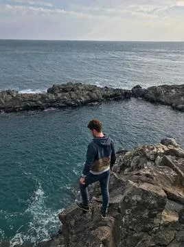 Young man posing and jumping on the sea side Stock Photos