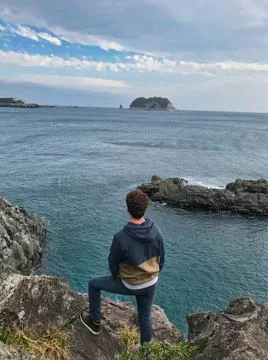 Young man posing and jumping on the sea side Stock Photos