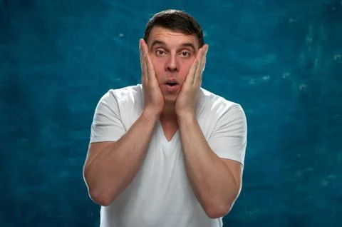 Young man posing on blue background Stock Photos