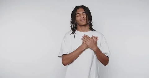 Young man posing confidently in a plain shirt against a neutral background,.. Stock Footage 313951136