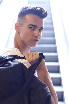 Young man posing with hands in hair by window Foto stock