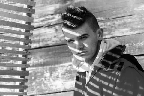 Young man posing in red jacket covered with beautiful film noir style shadow Stock Photos