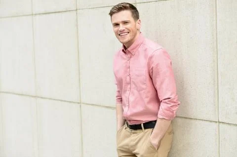 Young man posing smartly against wall Stock Photos