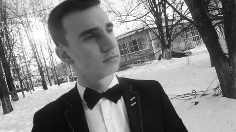 Young man posing in a tuxedo in the winter against the white snow,shot in retro Video stock 85070367