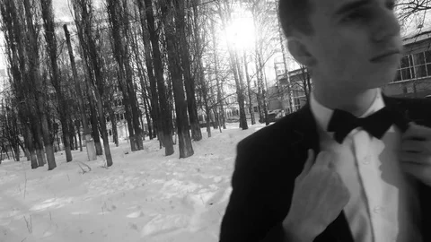 Young man posing in a tuxedo in the winter against the white snow,shot in retro Stock Footage 85070810