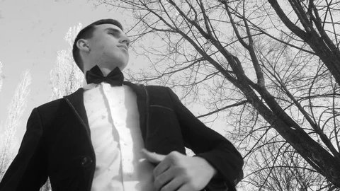 Young man posing in a tuxedo in the winter against the white snow,shot in retro Stock Footage 85071356