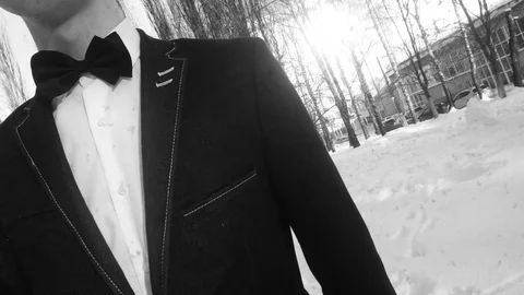Young man posing in a tuxedo in the winter against the white snow,shot in retro Video stock 85071628