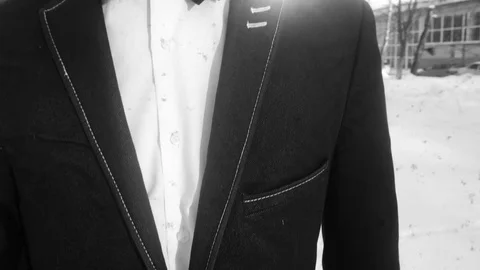 Young man posing in a tuxedo in the winter against the white snow,shot in retro Stock Footage 85071901