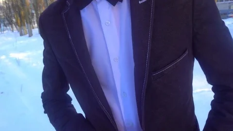 Young man posing in a tuxedo in the winter against the white snow Video stock 85136969