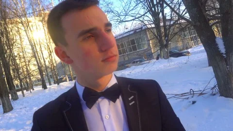 Young man posing in a tuxedo in the winter against the white snow,shot in retro Stock Footage 85137436