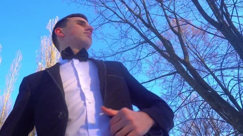 Young man posing in a tuxedo in the winter against the white snow,shot in retro Stock Footage 85139901
