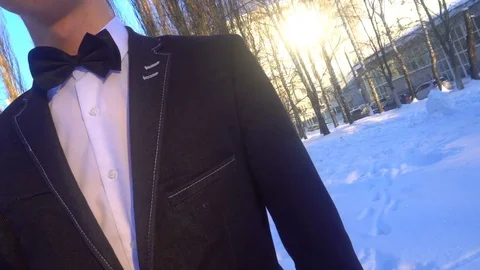 Young man posing in a tuxedo in the winter against the white snow,shot in retro Video stock 85140255