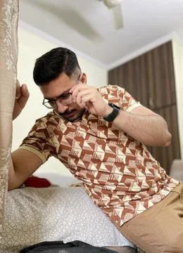 Young man posing while holding his glasses frame portrait at home room Foto stock