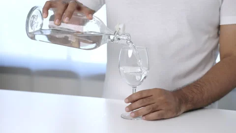 The young man poured clean drinking water into a glass, ready to drink. Natural  Stock Footage 153447650