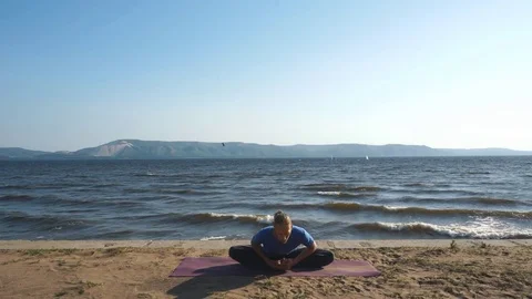 Young man practice yoga on the beach during retreat vacation Stock Footage 80673584