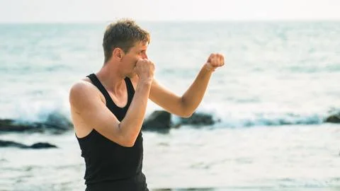 Young man is practicing boxing training in nature Stock Photos