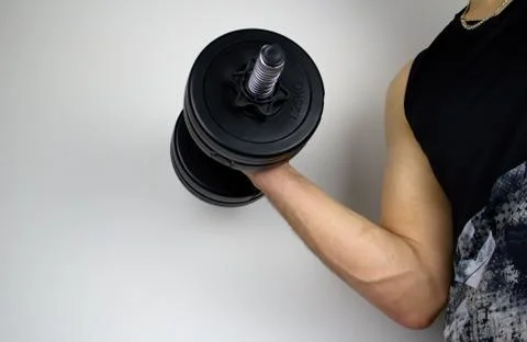 Young man practicing with a dumbbell Stock Photos