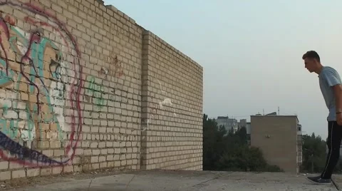 Young man practicing flips and jumps at the roof of building Stock Footage 67315398