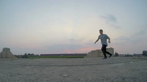 Young man practicing flips and jumps at the roof of building 库存影片 67315516