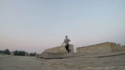 Young man practicing flips and jumps at the roof of building. PK Stock Footage 67315607