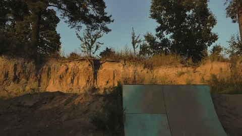 A young man practicing freestyle BMX in BMX park at dusk Stock-Footage 94965660